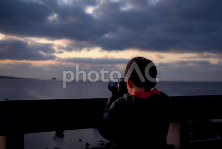 ※＜素材＞旅行で夜明けの海を撮影する少年 子供,男性,人物の写真素材