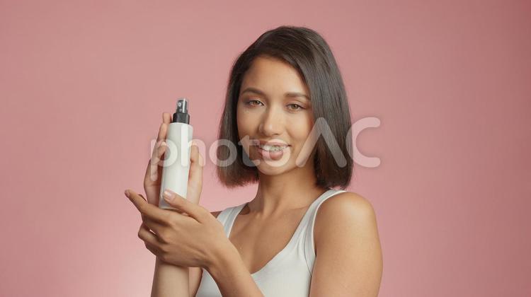 スプレーボトルを持って笑顔の女性 女性,外国人,アジア人の写真素材