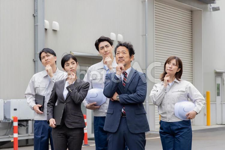  建物の前で考える会社従業員 工場,男性,考えるの写真素材