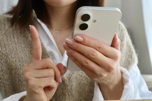 スマホを持つ女性　人差し指ポーズ スマホ,女性,1の写真素材
