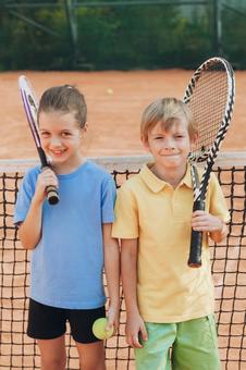 テニスネット前に立つ二人の子供 男の子,女の子,外国人の写真素材