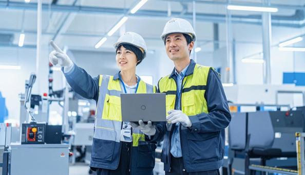 工場でタブレットで製品を検査する作業員 工場でタブレットで製品を検査する作業員の写真