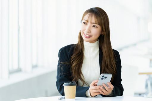 スマホを使う笑顔の女性・ビジネスウーマン 女性,スマホ,スマートフォンの写真素材