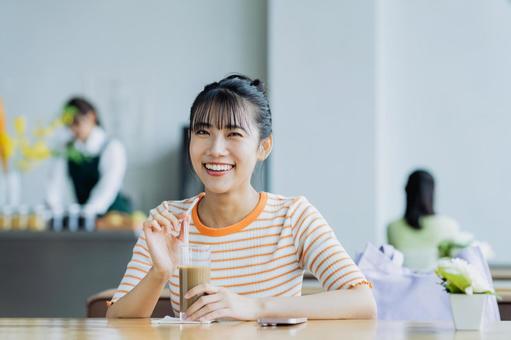 カフェでくつろぐ若い女性 カフェでくつろぐ若い女性 女性,カフェ,笑顔の写真素材