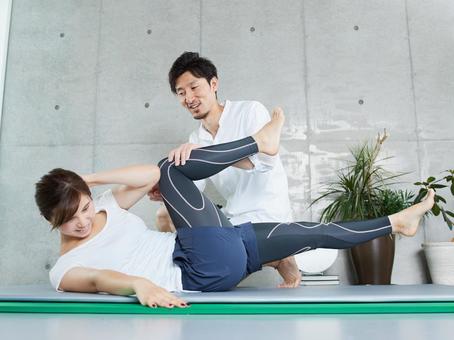 Japanese woman receiving abdominal training from a personal trainer Japanese woman receiving abdominal training from a personal trainer