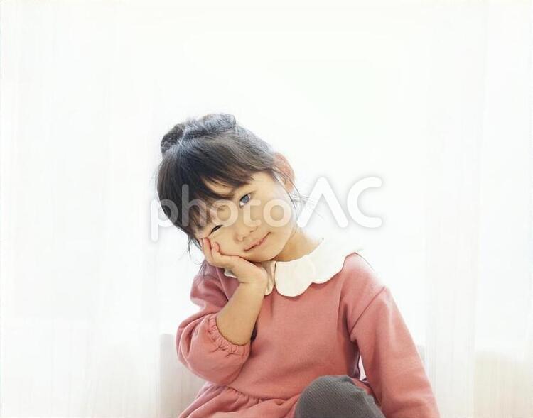 頬に手を当てウインクする女の子 子供,女の子,3歳の写真素材
