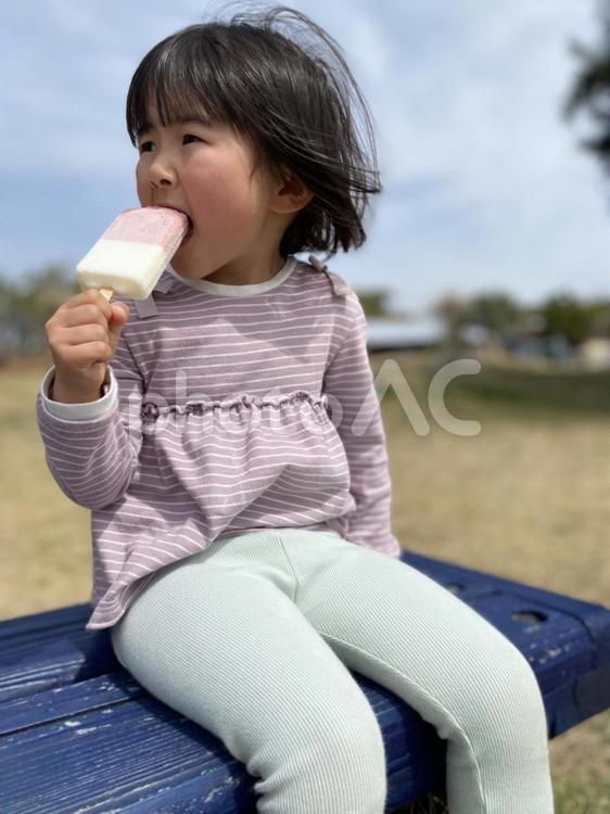ベンチでアイスを頬張る子供 ベンチ,アイス,アイスクリームの写真素材