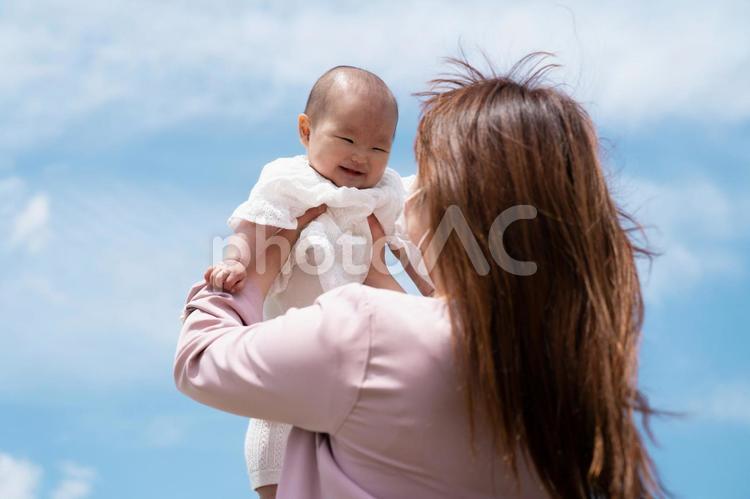 赤ちゃんを高い高いする女性（マスク） 赤ちゃん,ベビー,娘の写真素材