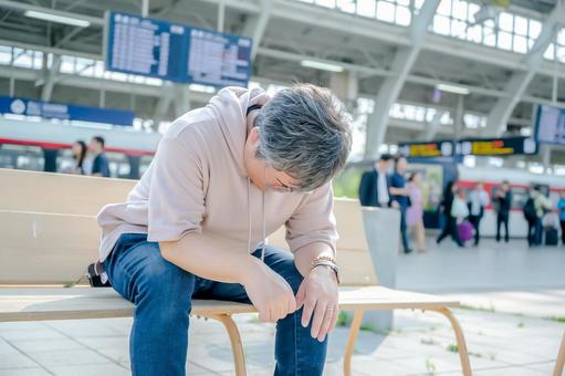 駅でうなだれる男性 駅でうなだれる男性 男性,中年,私服の写真素材