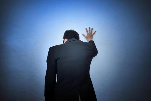 肩を落とす男性の後ろ姿 絶望,打ちひしがれる,どん底の写真素材