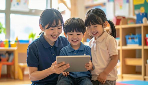 タブレットで遊ぶ保育士と子ども タブレットで遊ぶ保育士と子どもの写真