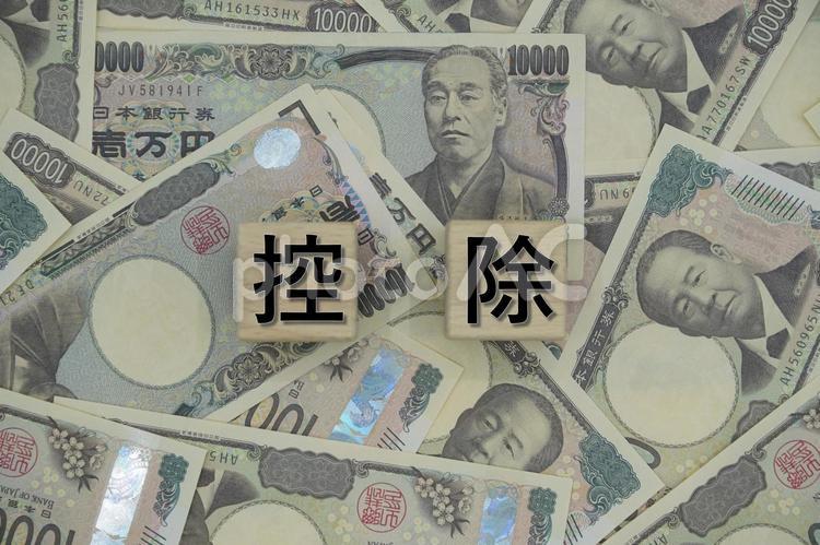 「控除」の文字と背面全面に万札 控除,税控除,節税の写真素材