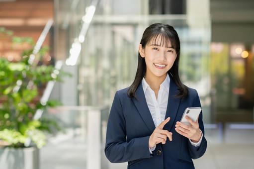 スマートフォンを使う若いビジネスウーマン スマートフォンを使う若いビジネスウーマン スマートフォン,スマホ,携帯電話の写真素材