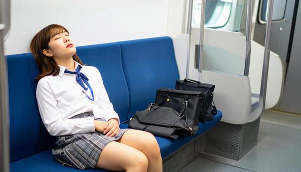 目を閉じて電車で寝落ちする女性 目を閉じて電車で寝落ちする女性の写真