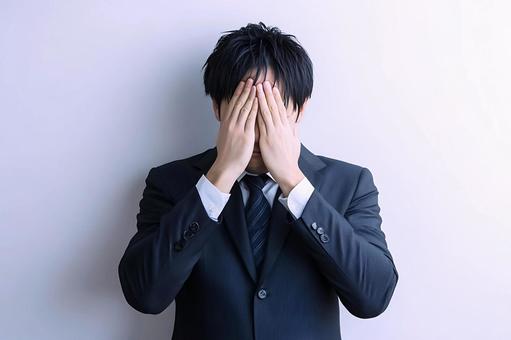 絶望しているスーツ姿の男性 絶望しているスーツ姿の男性の写真