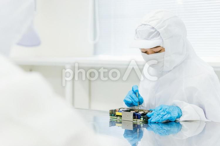 クリーンルームで精密機器を扱う女性 工場,製造業,精密機器の写真素材