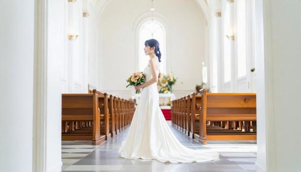 教会のバージンロードを歩く花嫁の横姿 教会のバージンロードを歩く花嫁の横姿の写真