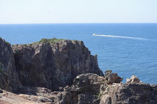 断崖絶壁と船と海と水平線と青空の風景 断崖絶壁,船,海の写真素材
