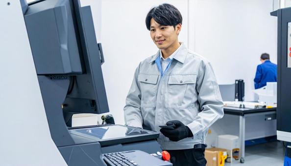工場の三次元測定機を使う作業服の男性 工場の三次元測定機を使う作業服の男性の写真