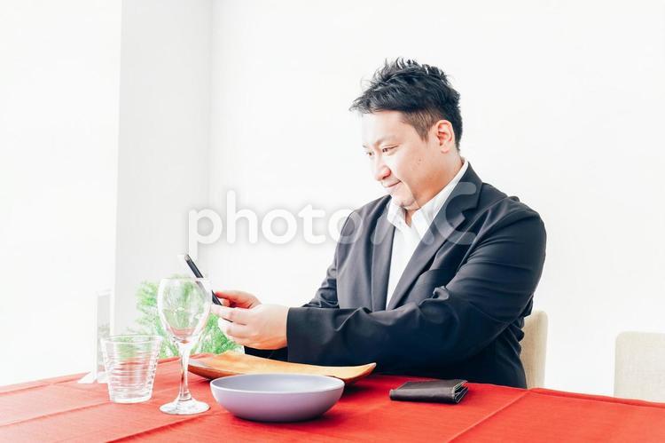 レストランでスマホ決済をする男性 スマホ,ポイント,テーブルの写真素材