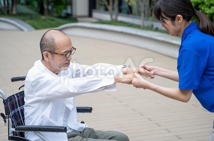 車いすから立ち上がる介助をするスタッフ 女性,介護,介護士の写真素材
