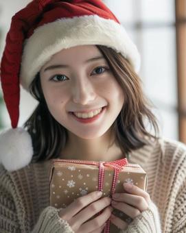 クリスマス　プレゼントを持つ女性の写真