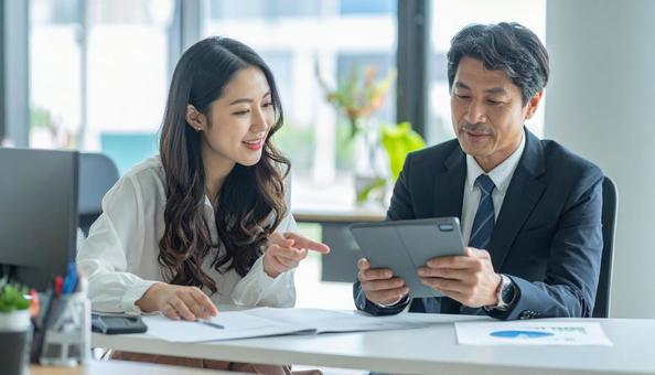 タブレットで打ち合わせするビジネス社員 タブレットで打ち合わせするビジネス社員の写真