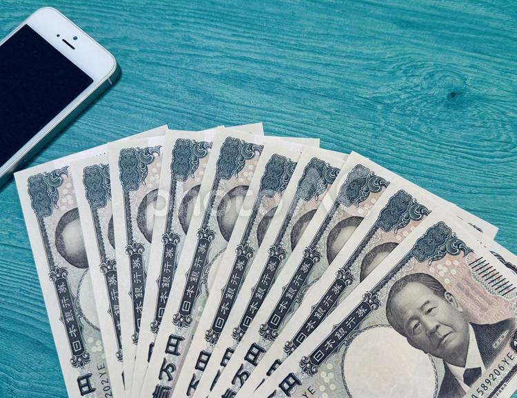 スマホとお金（1万円札10枚） お金,マネー,現金の写真素材