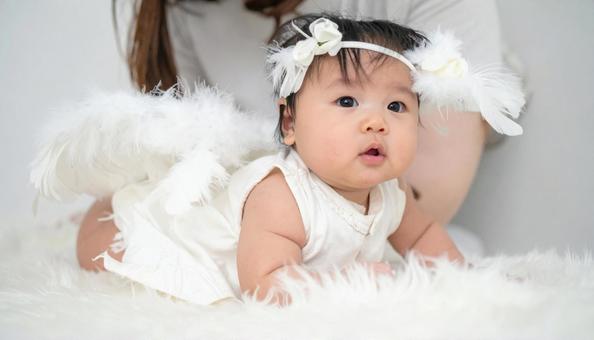 天使の恰好で記念撮影する日本人の赤ちゃんの写真