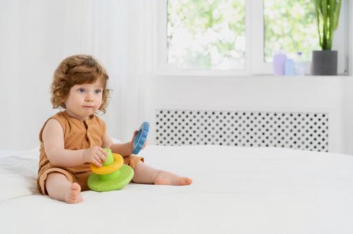 両手に玩具を持ちお座りしている子供 両手に玩具を持ちお座りしている子供 赤ちゃん,玩具,持つの写真素材