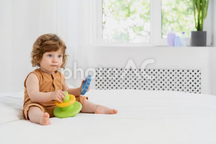 両手に玩具を持ちお座りしている子供 赤ちゃん,玩具,持つの写真素材