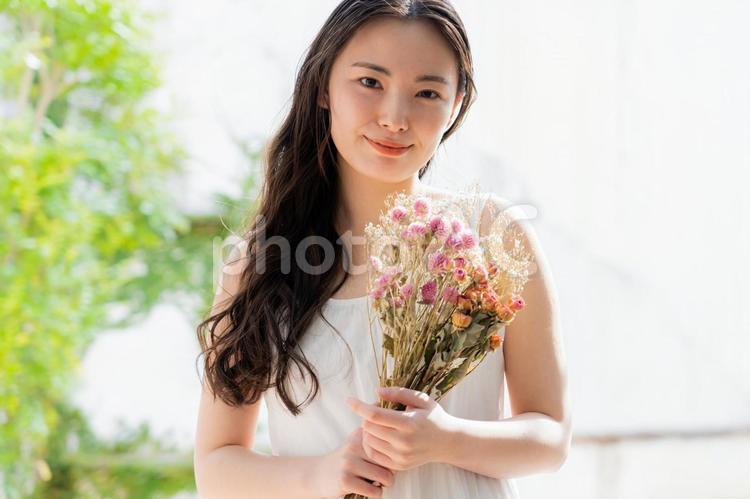 花束を持つ白いワンピースを着た女性 女性,花束,ブライダルの写真素材