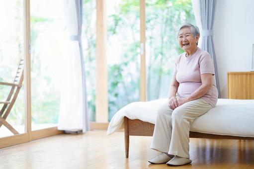 ベッドに座り笑っているおばあちゃん 女性,ベッド,座るの写真素材