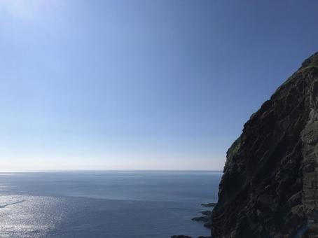 夏の海、崖から見る果てしなく続く水平線 夏の海、崖から見る果てしなく続く水平線の写真