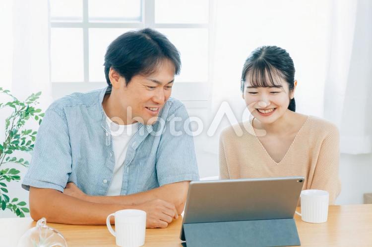 タブレットPCを見る夫婦（笑顔） タブレット,光テレビ,動画の写真素材