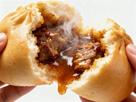 熱々でとろける肉まんを両手で割る写真 熱々でとろける肉まんを両手で割る写真の写真