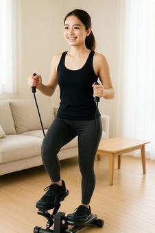 ステッパーで運動をする若い女性 ステッパーで運動をする若い女性の写真
