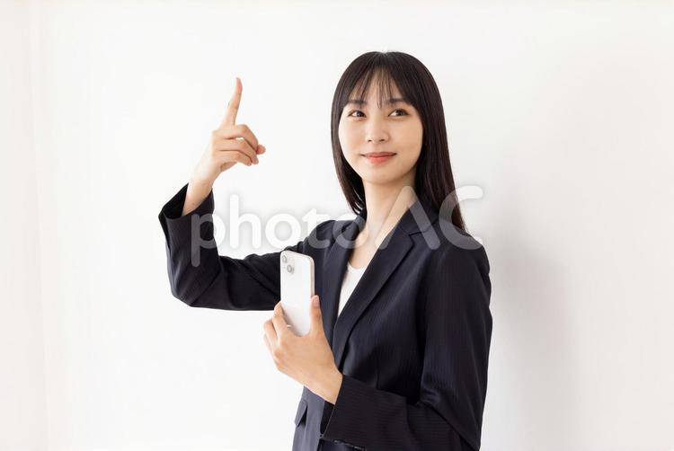 スマートフォンを持つビジネスウーマン 女性,ビジネスウーマン,指差しの写真素材