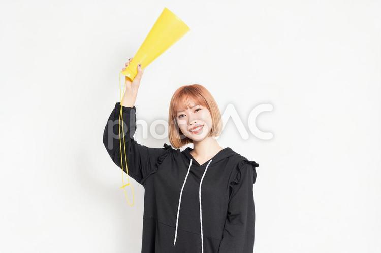 白背景の前で応援のジェスチャーをする若い女性 応援,声援,女性の写真素材