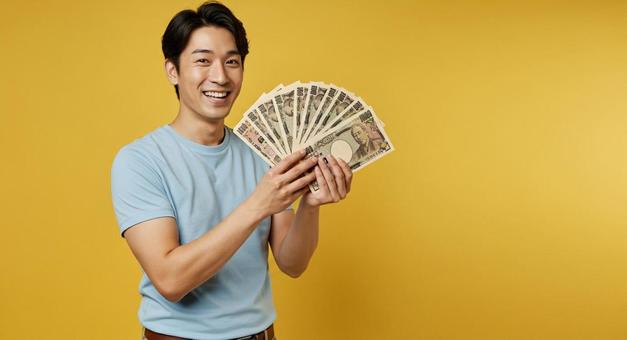 お札を手にして喜ぶ男性 お札を手にして喜ぶ男性の写真