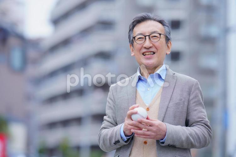 屋外で野球ボールを持っている高齢男性 男性,おじいちゃん,1人の写真素材