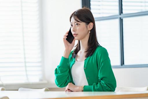 室内でスマートフォンを持ち電話をする女性 女性,スマートフォン,携帯電話の写真素材