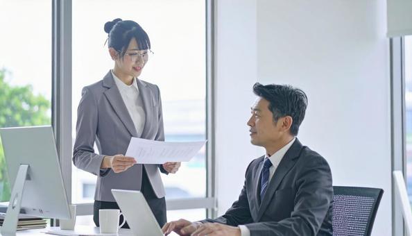 上司に報告する女性社員 上司に報告する女性社員の写真