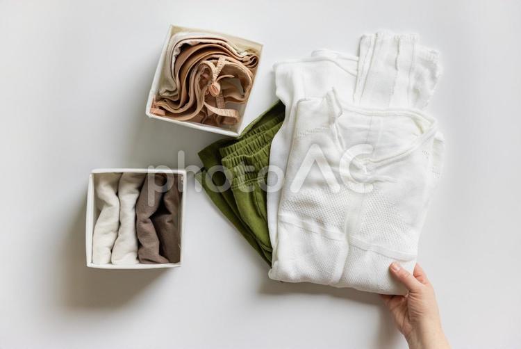 畳んだ洋服を持っている人の手元 手元,人物,ゼロエミッションの写真素材