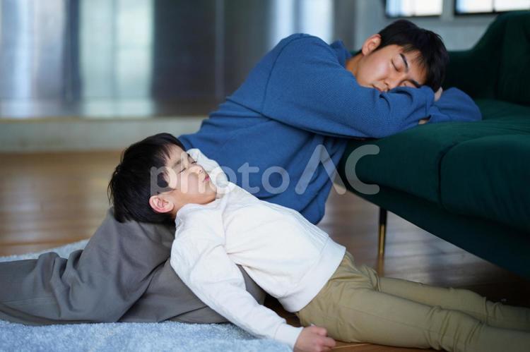 重なって寝ている親子 親子,男の子,小学生の写真素材