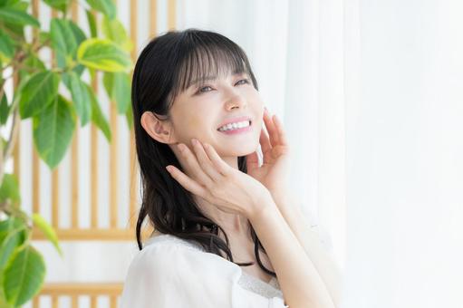 リビングでスキンケアをするミドルの女性 リビングでスキンケアをするミドルの女性 ビューティー,スキンケア,女性の写真素材