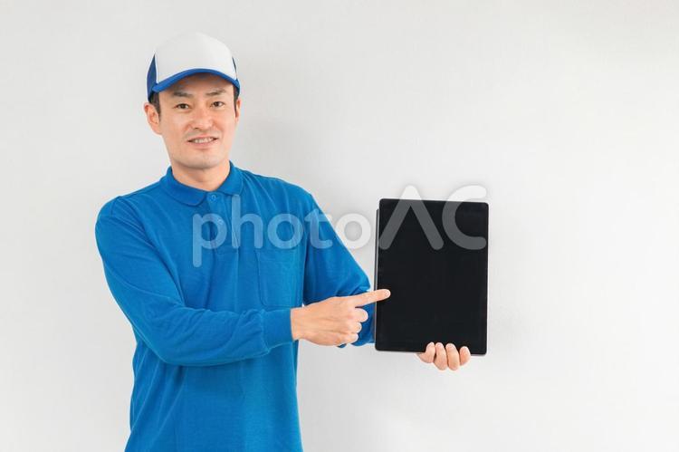 タブレットを持つ引越し業者・配達員の男性 タブレット,パソコン,プロバイダーの写真素材
