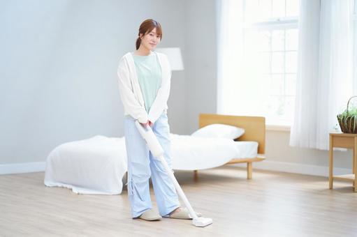 両手で掃除機を持ちカメラ目線の女性 女性,掃除機,掃除の写真素材