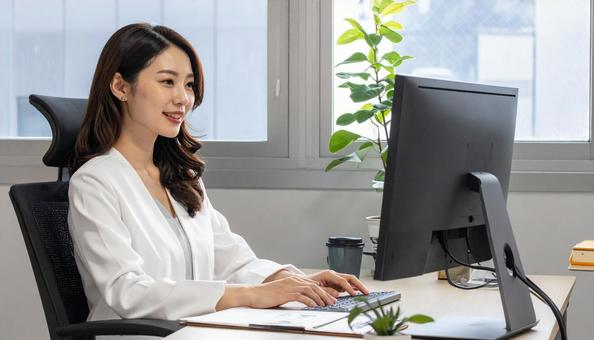 パソコンに向かって話す女性 パソコンに向かって話す女性の写真