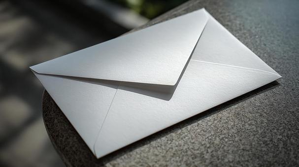 素朴な背景に佇む、シンプルな白い封筒 素朴な背景に佇む、シンプルな白い封筒の写真